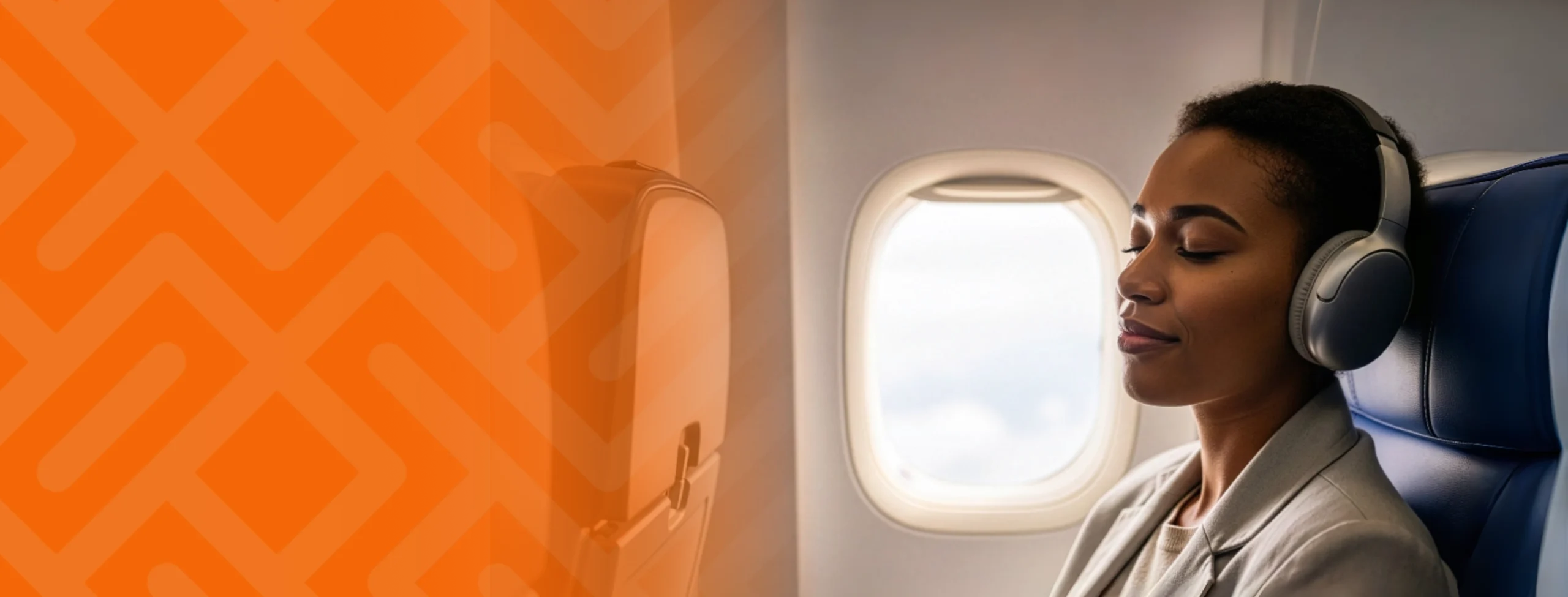 A traveller relaxing in a plane seat with headphones on, eyes closed, at peace